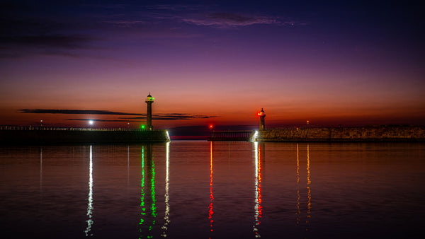 Pink aurora glow above the orange summer twilight at Whitby harbour, captured with a Nikon Z8